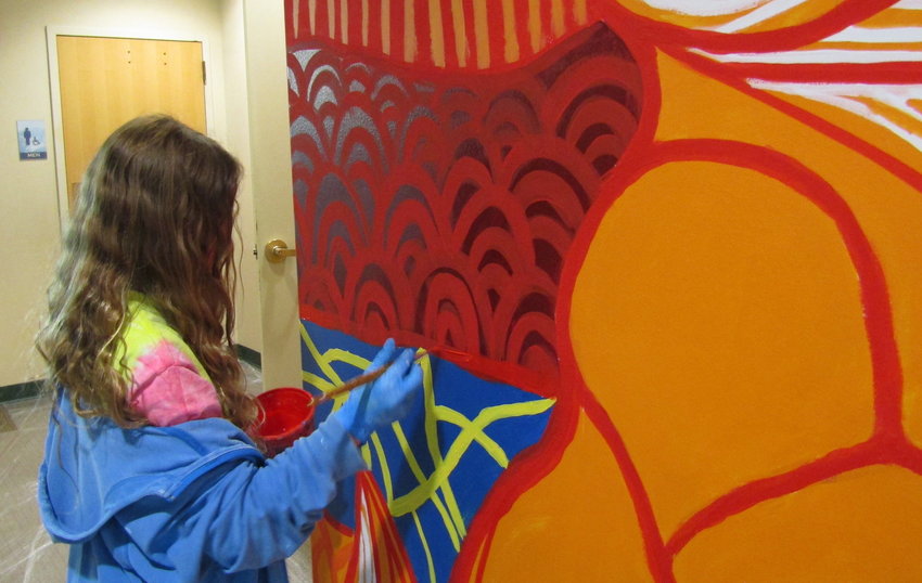 Nica Marques, 11, adds to the mural.